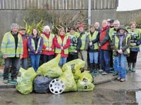 Dodging hailstorms to clean up village