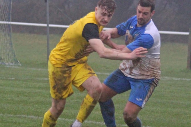 Callington's Noah Maund and Camelford's Andy Boxall battle it out in SWPL Premier West .