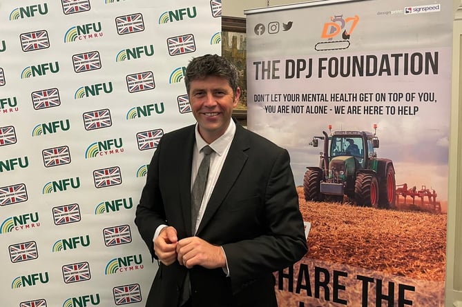 Scott Mann Mp for North Cornwall in front of an NFU poster after speaking out in support of rural mental health in Cornwall