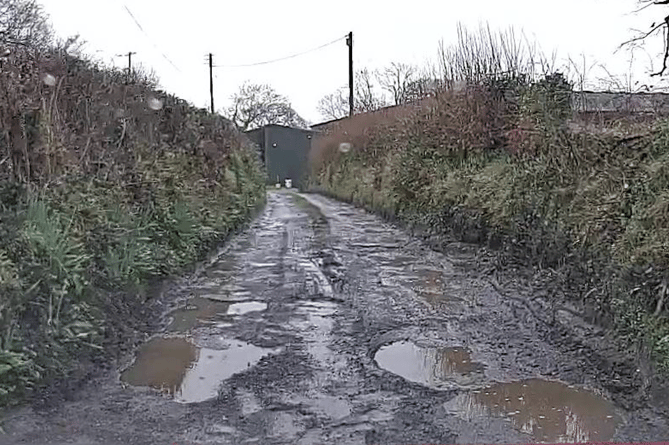 Pothole covered road near Holsworthy