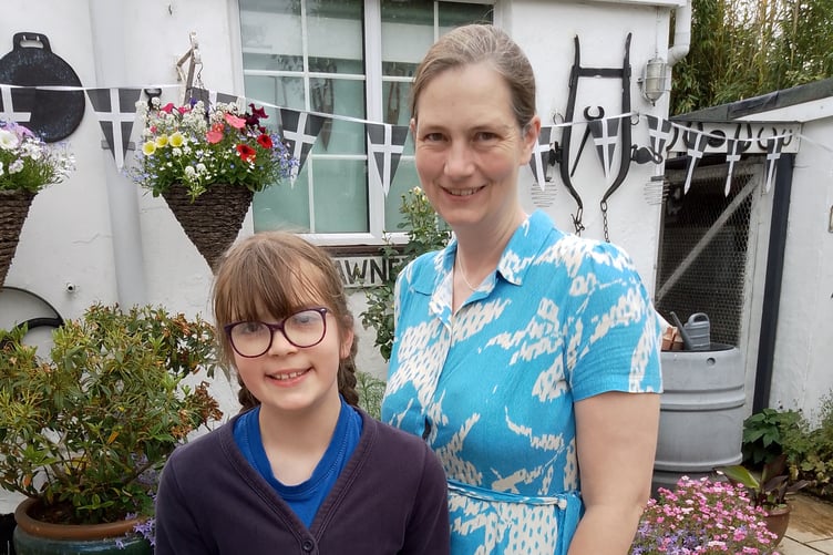 Ten year old Holly Cooper and her mother collecting the Dundee cake she won by guessing the weight