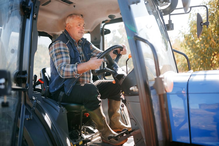 A seasoned farmer takes command of his domain as he sits behind the wheel of his trusty tractor, navigating the expansive field with skill and precision,