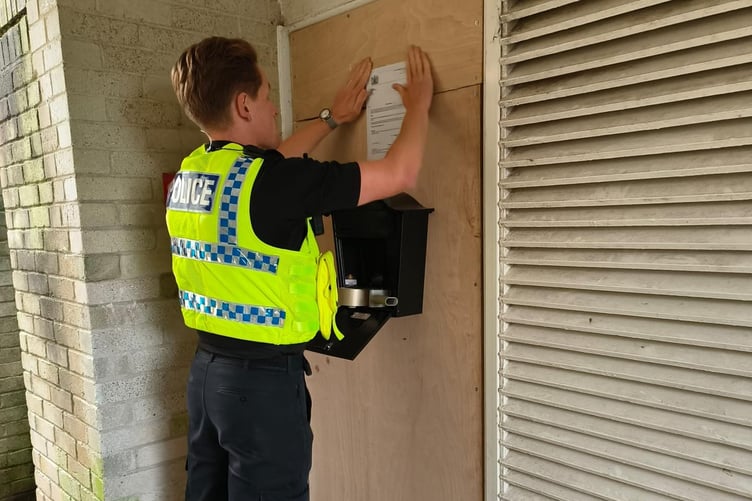 A Police officer displays the notice on the door of the property in Bodmin
