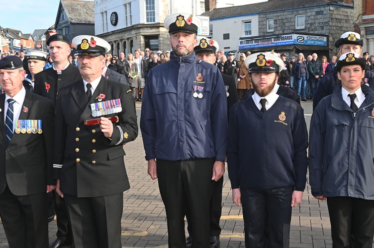 Members of the HM Coastguard stand to attention
