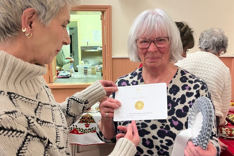 Judith Taylor proudly showing her RHS Gold Medal to fellow WI member Jane Libby