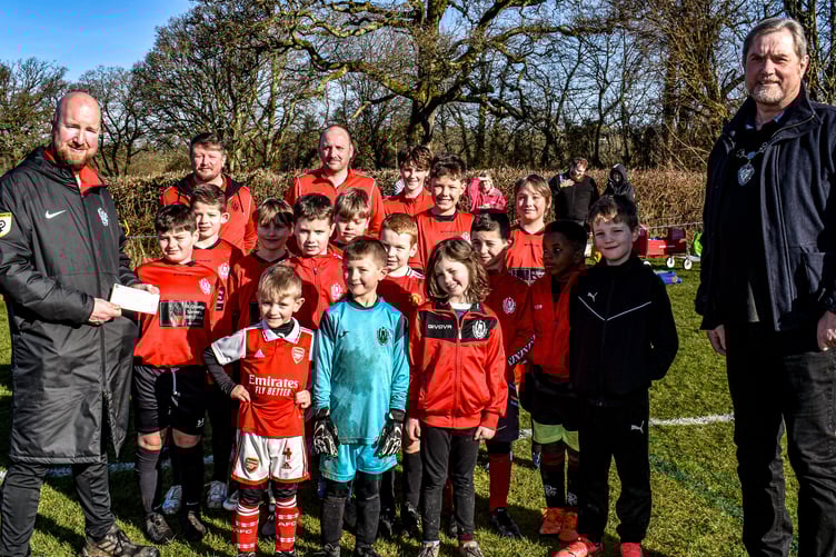 Hatherleigh FC is celebrating reaching it's target for buying a new site for a new pitch. The youth team is pictured receiving a donation on behalf of Hatherleigh Town Council.