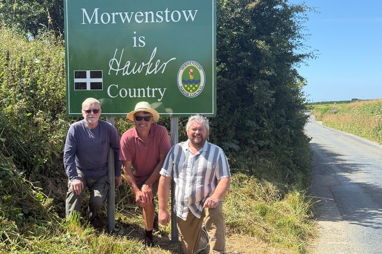 Pictured with Morwenstow's sign marking its association with Rev Robert Stephen Hawker are Alan Rowland, David Miles and Jonathan Hobbs