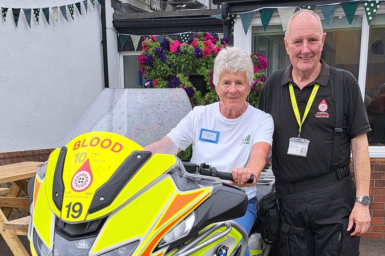 Bude Women's Institute President Cynthia May is pictured with Cornwall Blood Bikes volunteer Alan Chowings