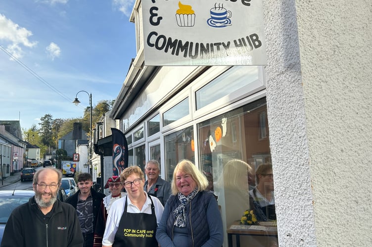 The launch of the new Pop-In Cafe and Community Hub in Gunnislake – a dream come true for founder Ruth Kelly-Williams, centre, and her fiance Andrew Cuer, back right. Also pictured, from left, signwriter Chris Clarke (left) and his wife, Gunnislake ward parish councillor, also Chris Clarke, right, who did the cafe flowers.  Cutting the ribbon was Cornwall councillor for Calstock Angus Black (back left, Reform UK), while Calstock town crier Hilary Fairhurst, back in her regalia, performed a special 'cry' in honour of the occasion.