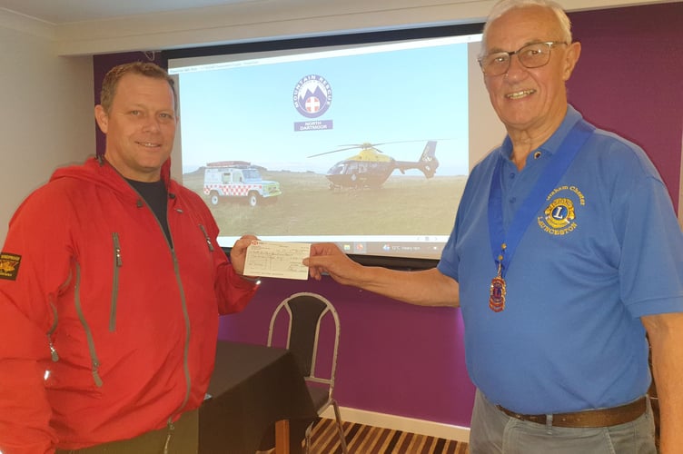 Lions Club of Launceston president Graham Chester, presenting Roger Clarke of the North Dartmoor Search and Rescue Team, with a cheque for £200