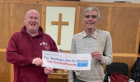 Darren Tait (left) from Sending Love to Ukraine receiving a cheque from Paul Jellyman of the Launceston Community Market